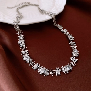Detailed view of silver zircon rectangular link necklace on elegant red silk background