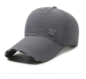 Close-up of breathable mesh fabric and embroidered letter M on grey baseball cap