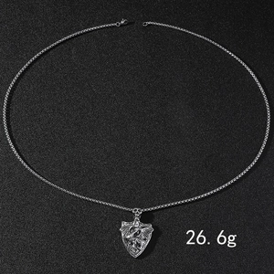 Gros plan du pendentif cœur tête de mort ailé de 26,6g sur une chaîne en acier