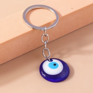 Detailed macro shot of blue glass Evil Eye pendant with polished silver key ring