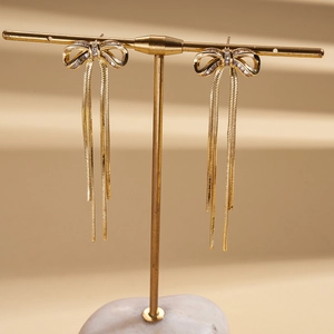 18K gold plated bowknot tassel earrings with clear zircon stones on golden display