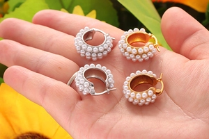 Detail of gold and silver chunky hoop earrings with pave set faux pearls in pairs