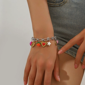Detail of multi-charm bracelet with heart and flower pendants on model's wrist