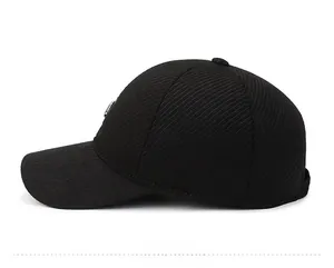 Close-up side view of black winter baseball cap with ribbed texture and metal logo