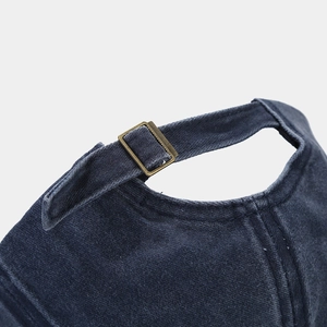 Detail of adjustable metal buckle and washed twill fabric on back of baseball cap
