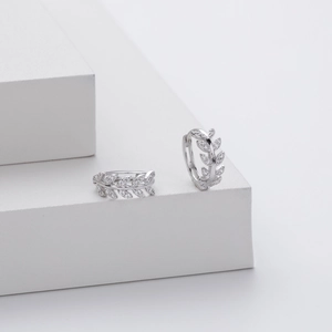 Detail of silver S925 leaf earrings with sparkling cubic zirconia on white background