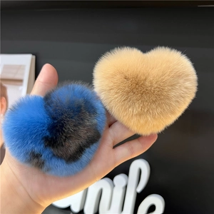 Detailed view of heart-shaped faux fur plush hair clips in marbled blue and yellow