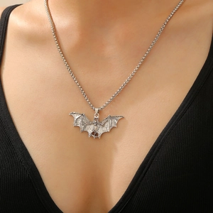 Close-up of a silver bat pendant on a punk gothic necklace worn by a female model
