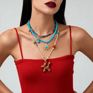Gros plan de colliers de perles superposés avec pendentif soleil et perles colorées