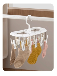 Detail of white multi-clip sock drying rack with non-slip clips for laundry organization