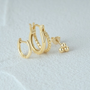 Detail view of gold-plated S925 sterling silver earring set with textured hoop and stud