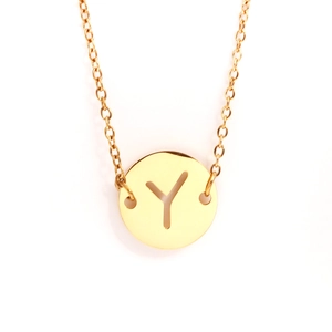 Gros plan du collier en acier doré avec un pendentif pièce lettre Y ajouré élégant