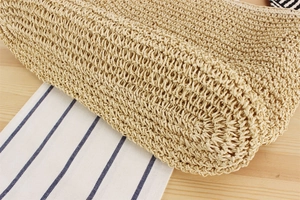 Detailed macro shot of natural woven paper rope texture and folded edge on beach bag