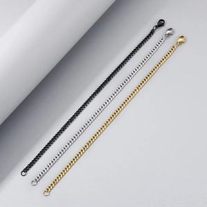 Close-up of stainless steel curb chain bracelets in black, silver, and gold finishes