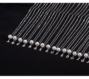 Detailed close-up of S925 silver pearl necklaces with shimmering rhinestone letters