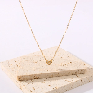 Elegant gold titanium heart pendant necklace with shimmering pave zircons on stone decor