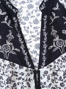Détail du col en V à imprimé fleuri avec bouton unique sur une chemise pour femme