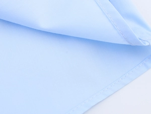 Nahaufnahme der feinen Nähte und Baumwollpopeline-Textur am hellblauen Hemdsaum