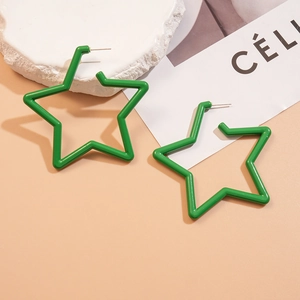 Détail de boucles d'oreilles créoles étoiles en acrylique vert sur fond minimaliste chaud
