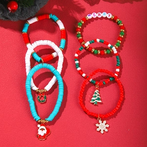 Christmas clay bead bracelet set featuring Santa and snowflake charms on red background
