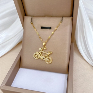 Elegant gold bicycle pendant necklace with sparkling crystals in a brown gift box