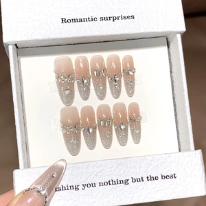 Sparkling pink press-on nails with rhinestones and metal chains in a white gift box