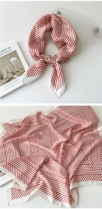 Detail of red and white geometric silk scarf tied and flat to show striped patterns