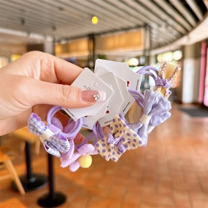 Detailed view of handmade purple bow hair ties with polka dots and plaid patterns