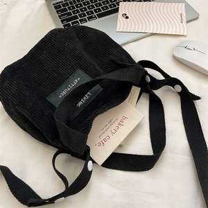 Détail du mini sac seau en velours côtelé noir avec écussons brodés Attitude Living