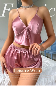 Detail view of pink satin two-piece sleepwear set with camisole top and elastic shorts