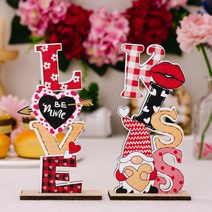 Close-up of wooden LOVE and KISS table ornaments with heart patterns for Valentine decor