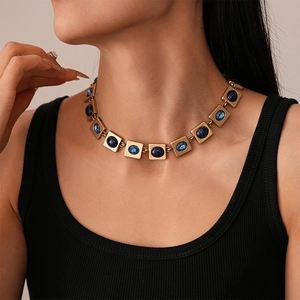 Close-up of vintage gold square link necklace with inlaid deep blue oval resin stones
