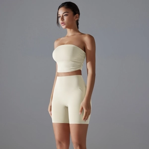 Detail view of cream two-piece yoga set showing side ruching and high waist shorts