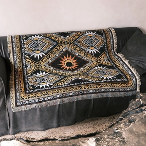 Detailed view of bohemian knitted blanket with sun and moon pattern and tassels