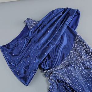 Close-up of royal blue velvet dress with shimmering silver rhinestone details