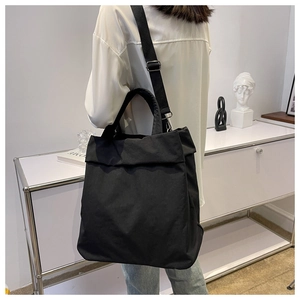 Detailed view of the large black nylon tote bag showing durable texture and wide strap