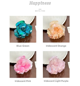 Detail of four colorful acetate rose hair claw clips in blue, orange, pink and purple