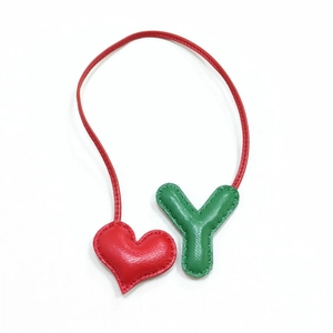 Dettaglio del ciondolo per borsa con cuore rosso e lettera Y verde in pelle martellata