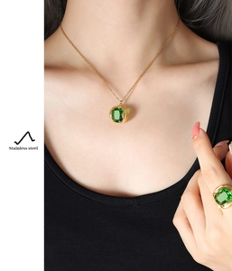 Close-up of emerald green rectangle crystal necklace and matching stainless steel ring