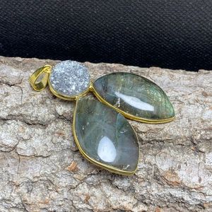 Macro detail of natural labradorite and druzy stone pendant with gold plating