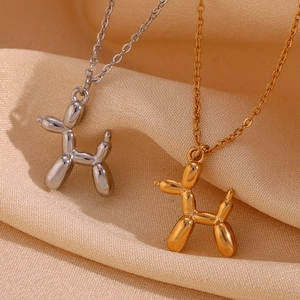 Macro detail of 3D balloon dog pendant in polished gold and silver stainless steel