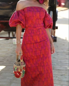 Detail der schulterfreien Puffärmel und des leuchtenden rosa-orangen Blumendrucks am Maxikleid