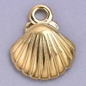 Close-up of golden stainless steel shell pendant with detailed texture on purple fabric