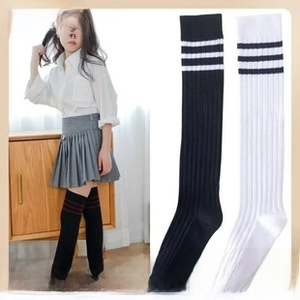 Detail of baby knee-high socks featuring three-stripe athletic cuffs and ribbed texture
