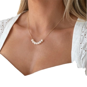Y-shaped gold plated necklace with six natural freshwater pearls on a female model