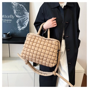 Detail of khaki puffer tote bag with quilted texture and adjustable shoulder strap