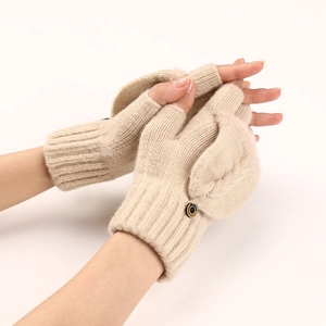 Dettaglio di guanti in maglia beige con chiusura a bottone e polsini a coste