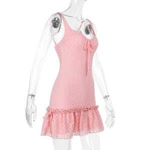 Vue détaillée d'une robe en dentelle rose avec nœud et ourlet à volants de profil