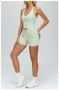 Cross-waist detail on mint green high-waisted yoga shorts with elastic V-neck sports bra