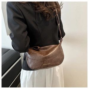 Borsa a tracolla retrò marrone scuro in similpelle abbinata a un blazer nero